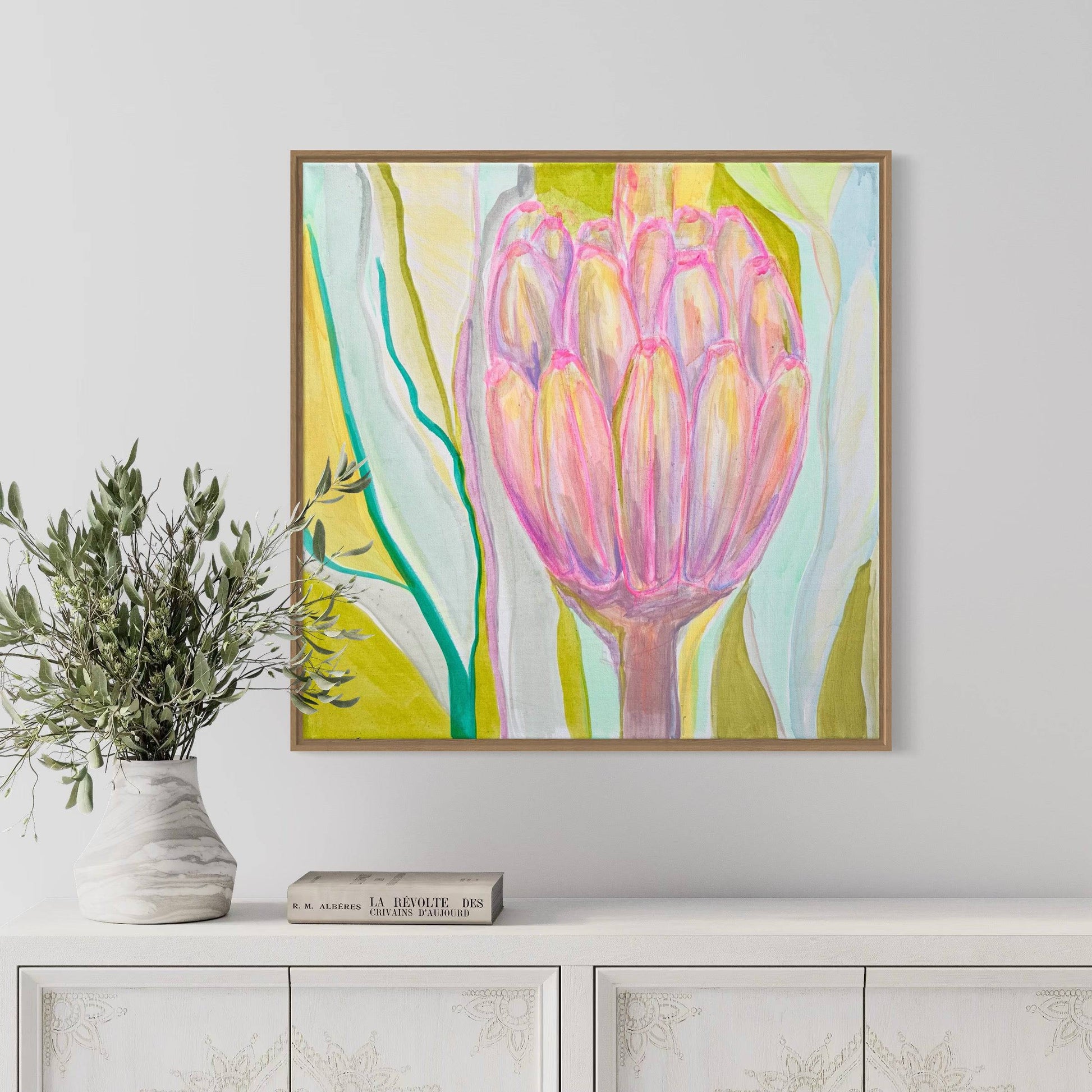 Abstract botanical painting in pink, green, and yellow hues by Kathryn Sillince on gallery wall above white cabinet