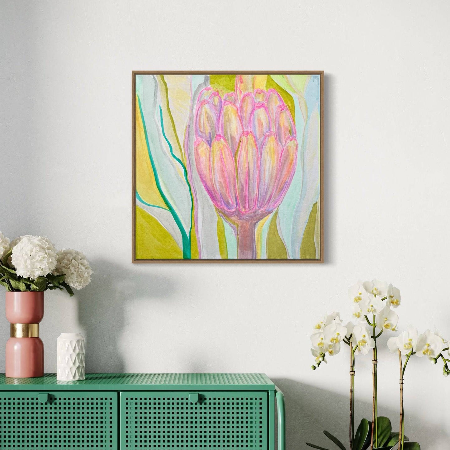 Abstract botanical painting of a pink protea flower with green and yellow background by Kathryn Sillince, displayed on a white wall above green cabinet with flowers