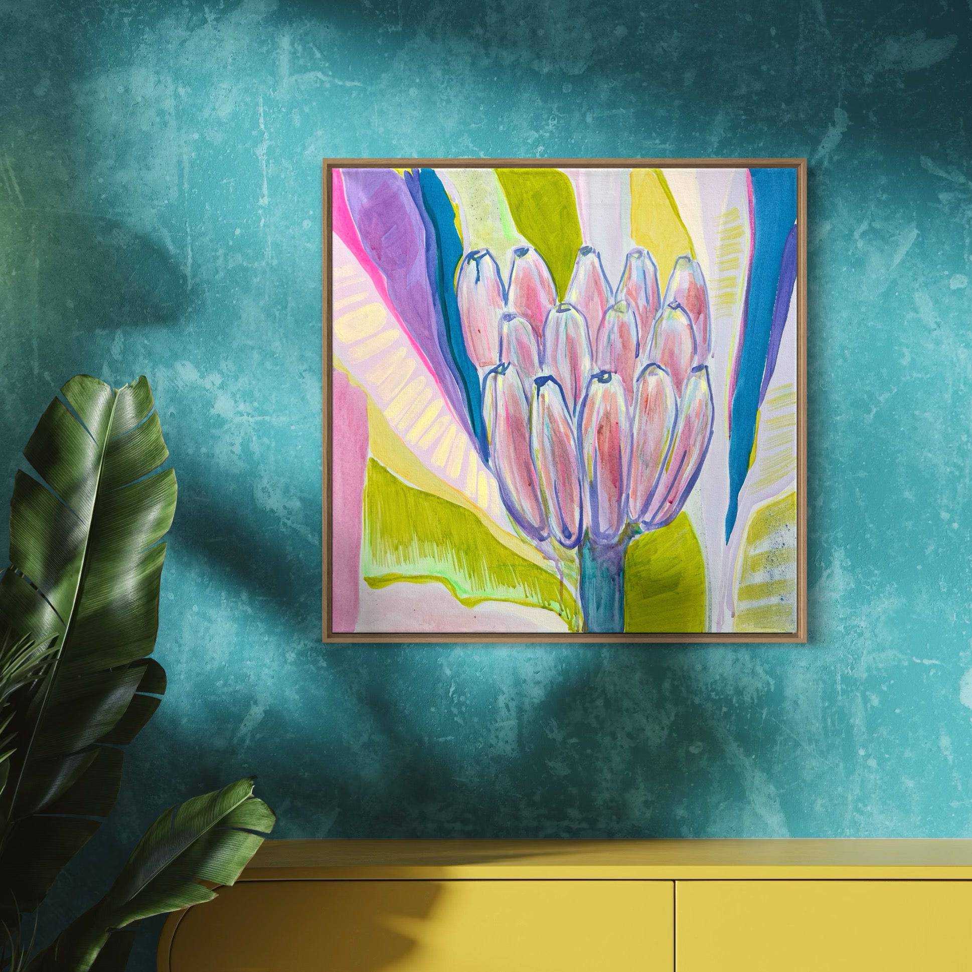Colorful botanical painting of bananas in pink, yellow, and blue hues by Kathryn Sillince on teal wall