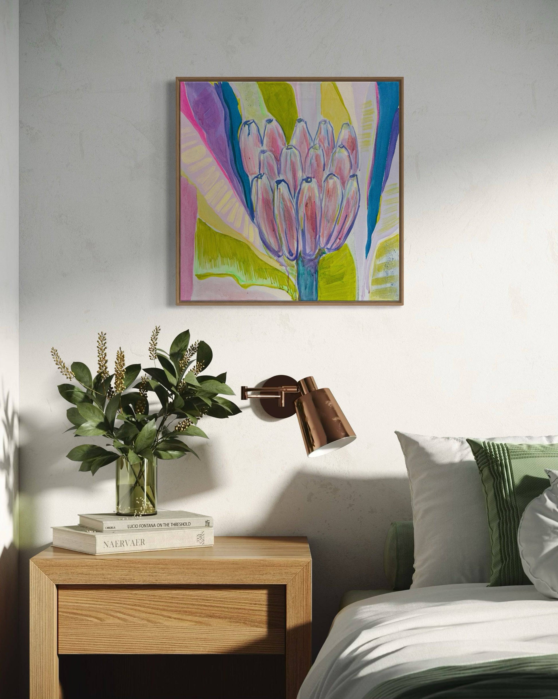 Bright botanical abstract painting with pink and green hues above wooden bedside table and bed with green pillows