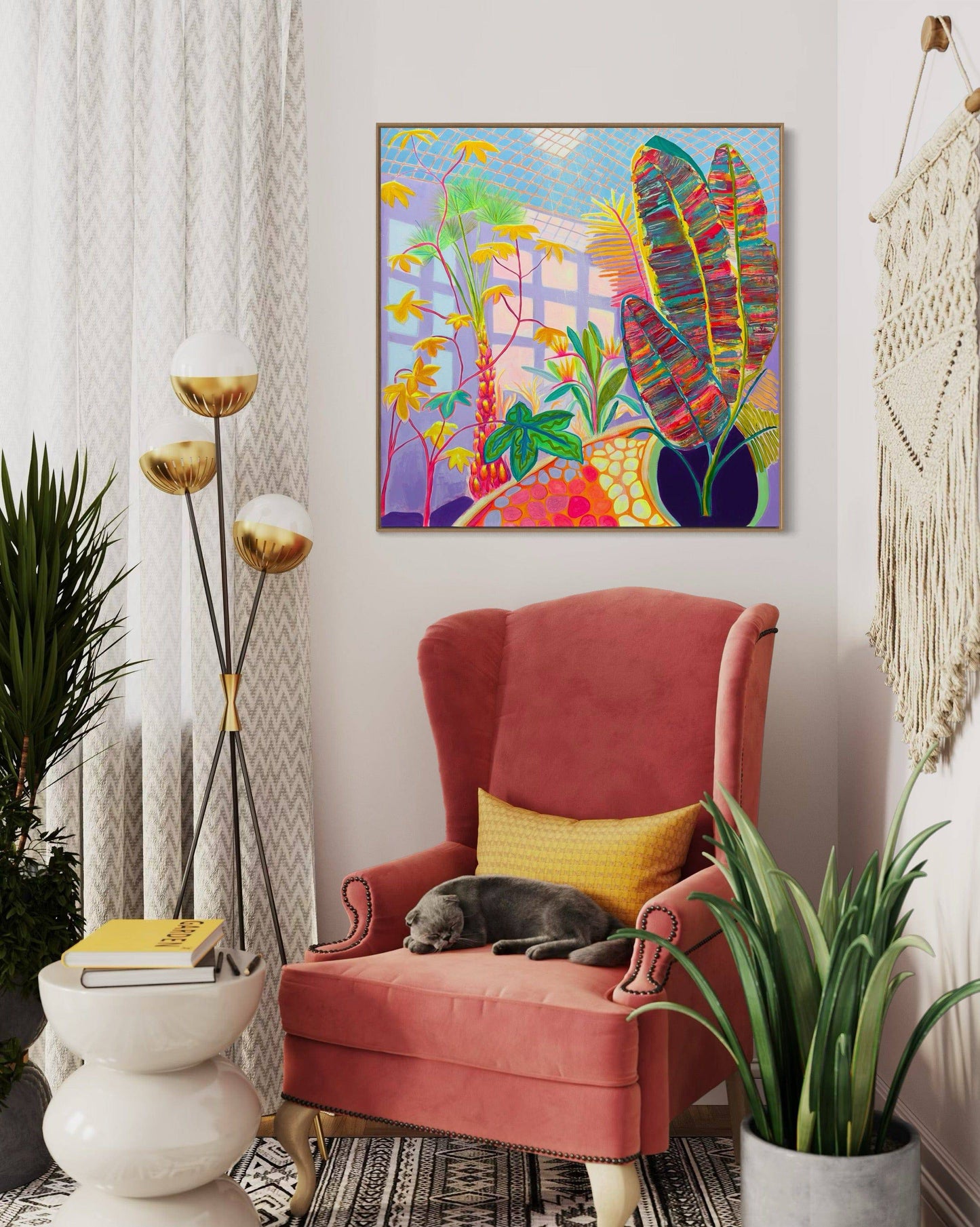 Cozy reading nook with pink velvet armchair, sleeping gray cat, colorful botanical painting by Kathryn Sillince above