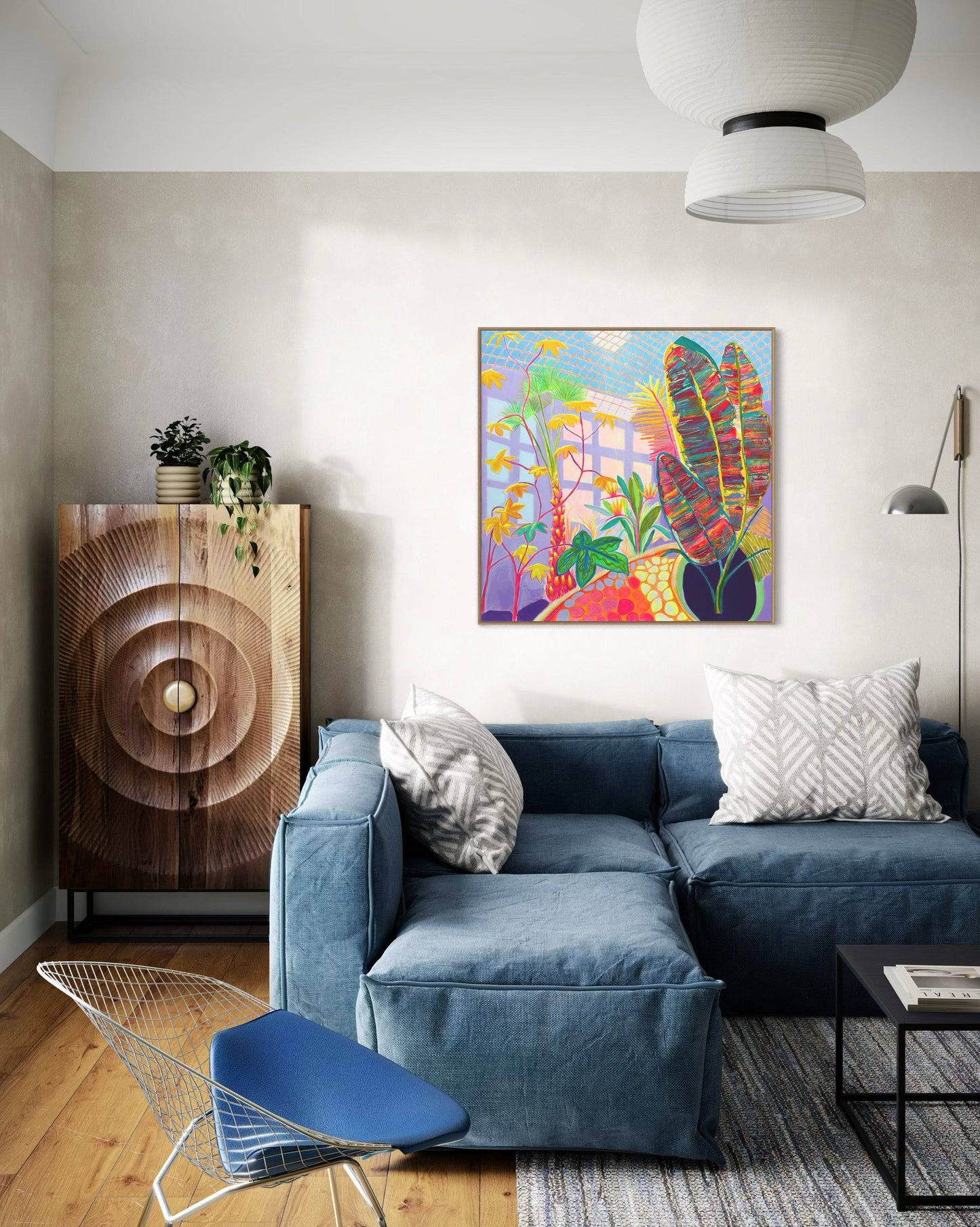 Modern living room with blue sectional sofa, botanical abstract painting by Kathryn Sillince on wall