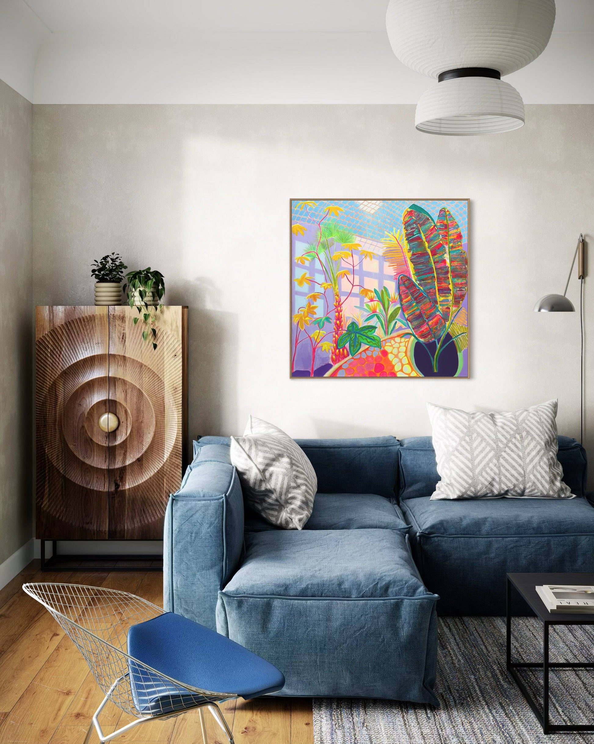 Modern living room with blue sectional sofa, botanical abstract painting by Kathryn Sillince on wall