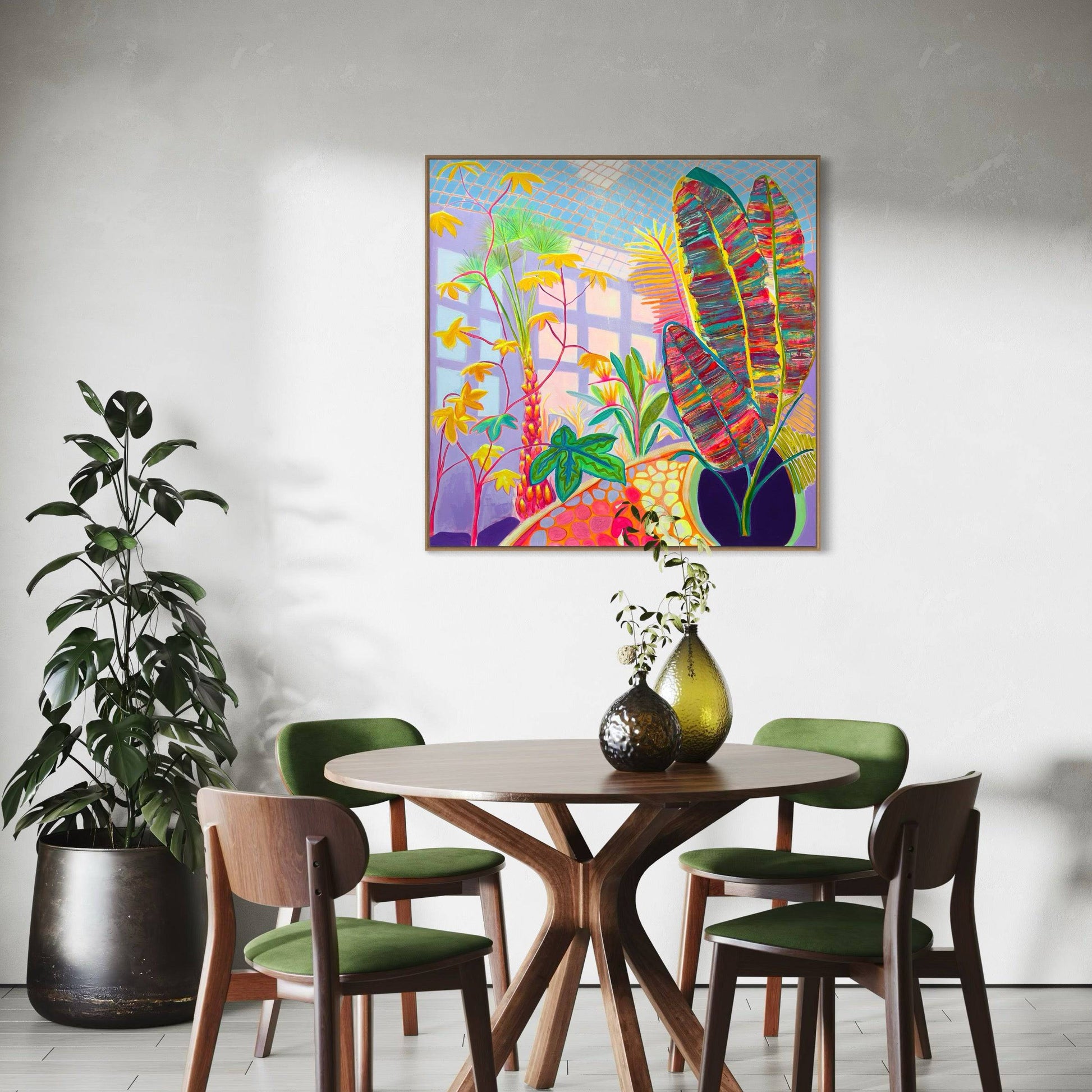Modern dining room with wooden round table, green chairs, potted plant, and colorful abstract botanical painting by Kathryn Sillince