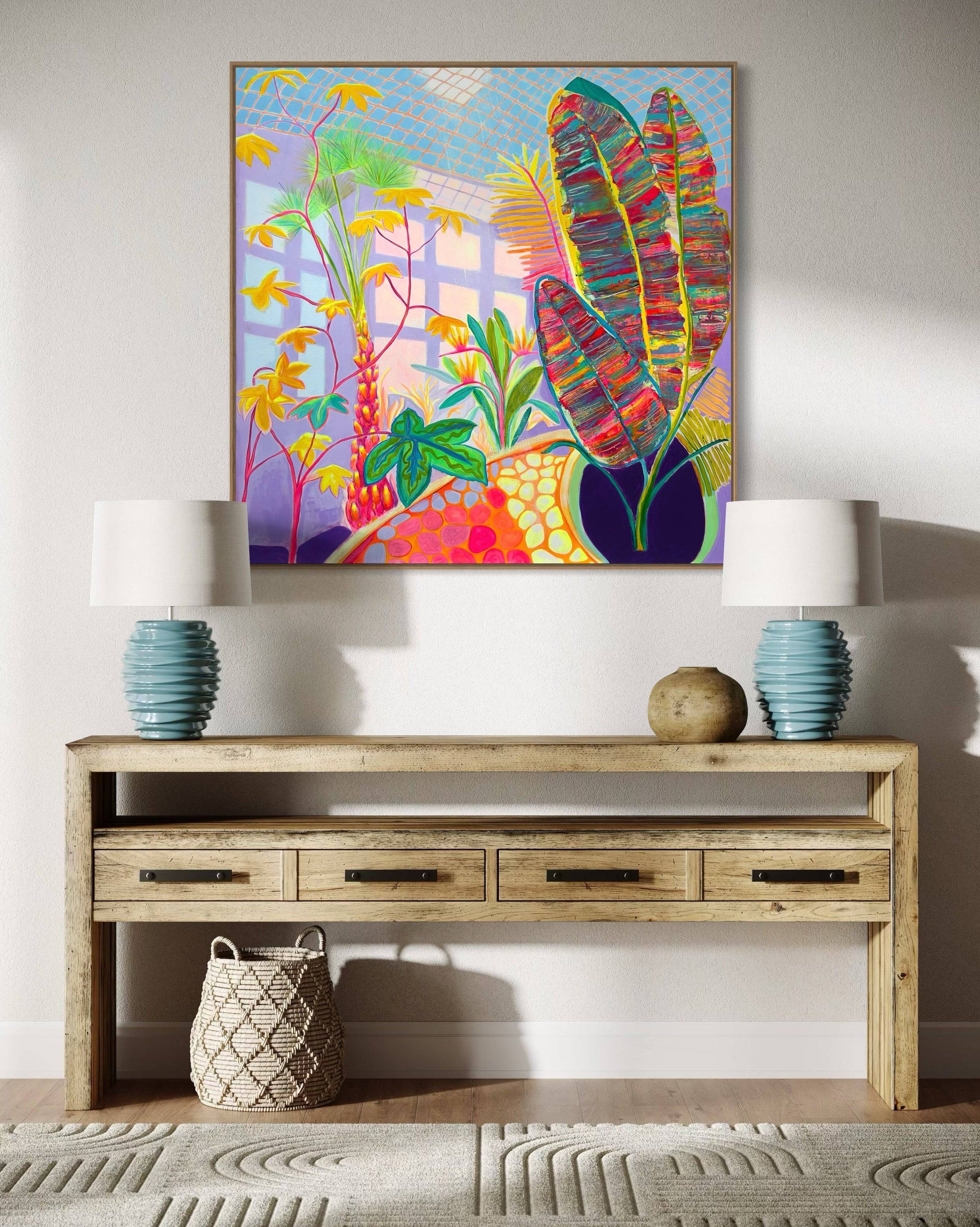 Colorful botanical abstract painting with vibrant leaves and flowers above rustic wooden table with blue lamps