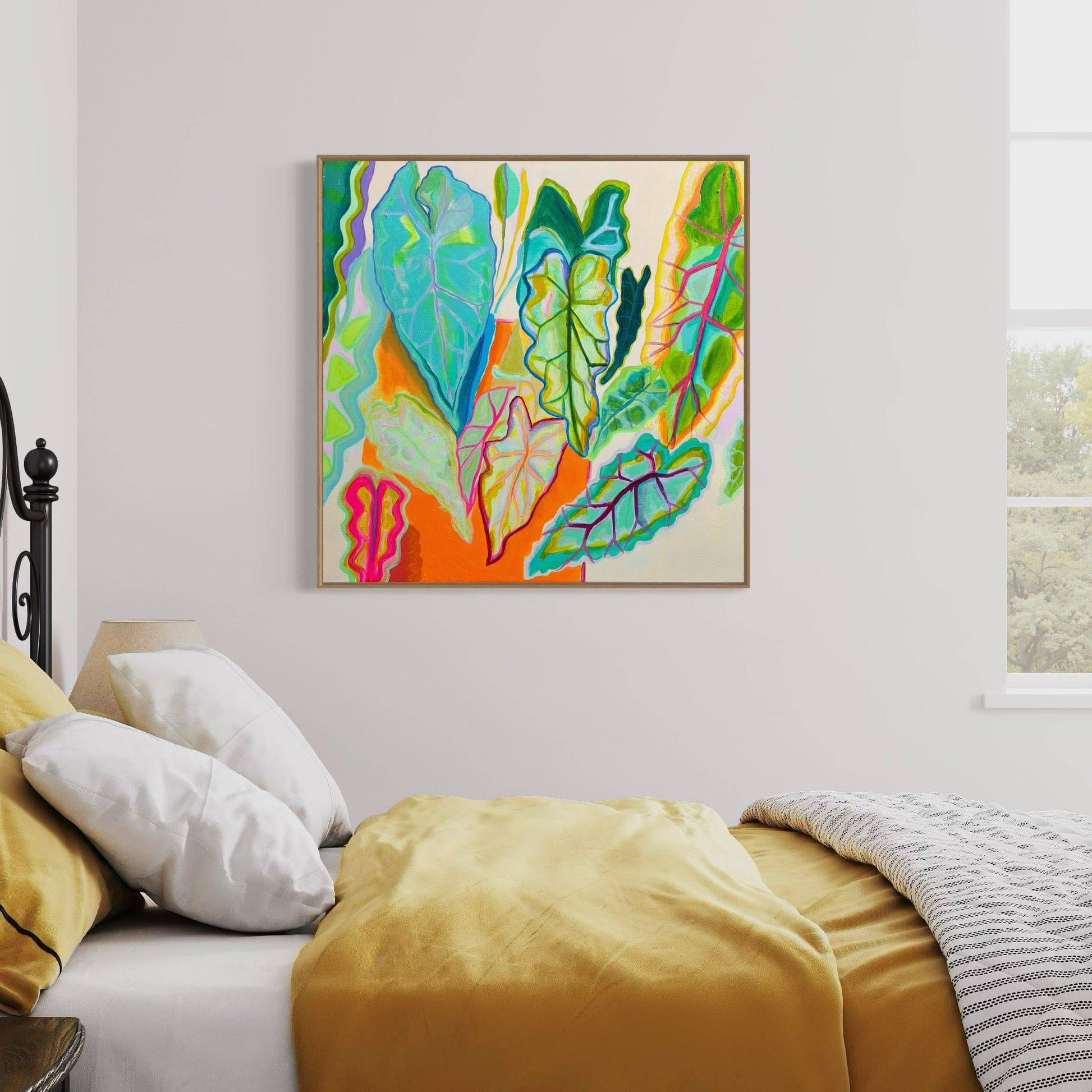 Abstract botanical painting with colorful leaves in turquoise, green, pink, and orange hues framed on a bedroom wall