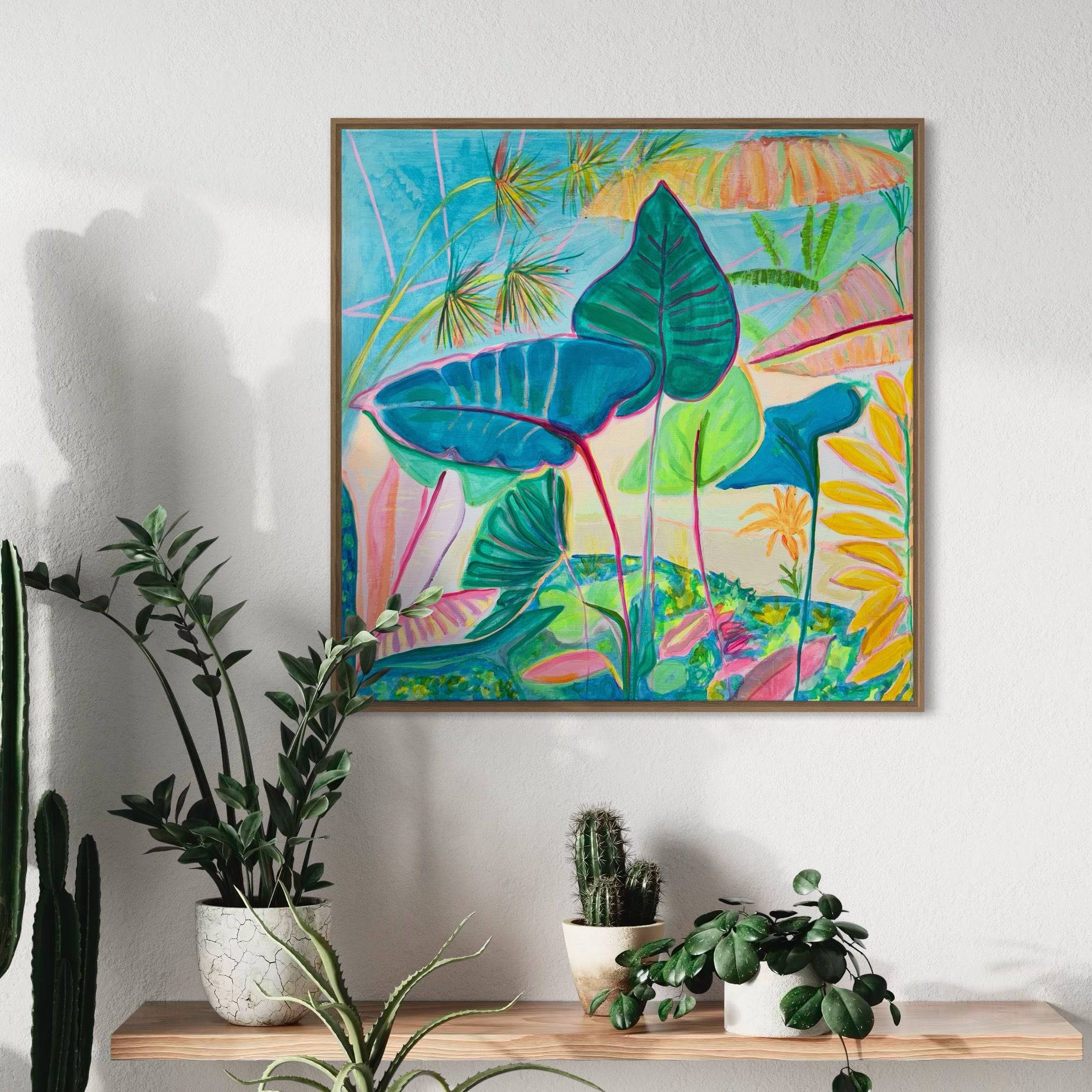 Colorful botanical abstract painting by Kathryn Sillince with large green and blue leaves in a wooden frame on wall above a wooden shelf with potted plants