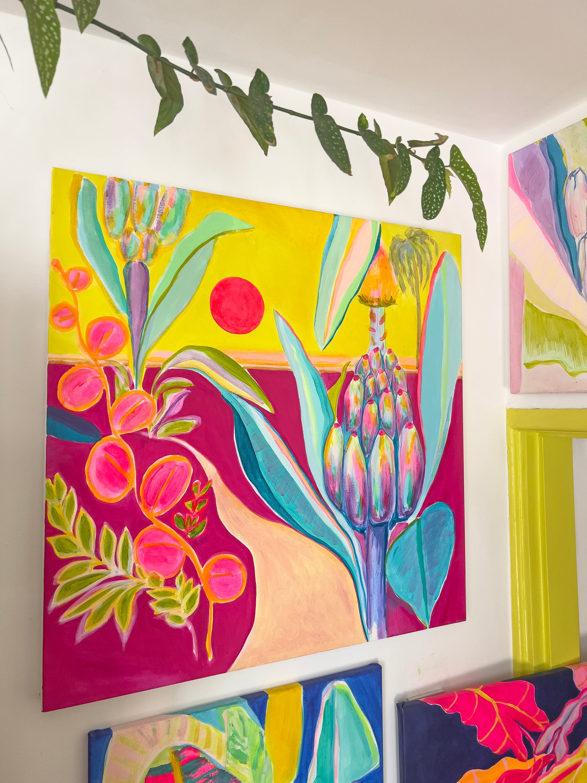 colourful contemporary landscape painting by kathryn sillince with banana plant and red sun in a wall