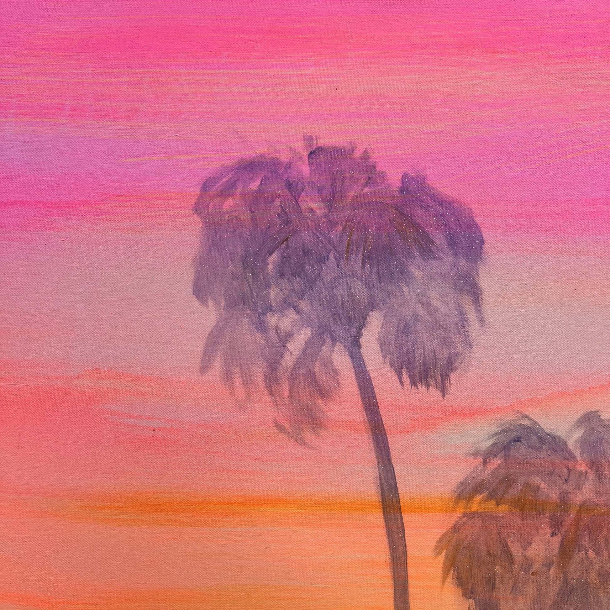 Palm trees against a pink and orange sunset sky