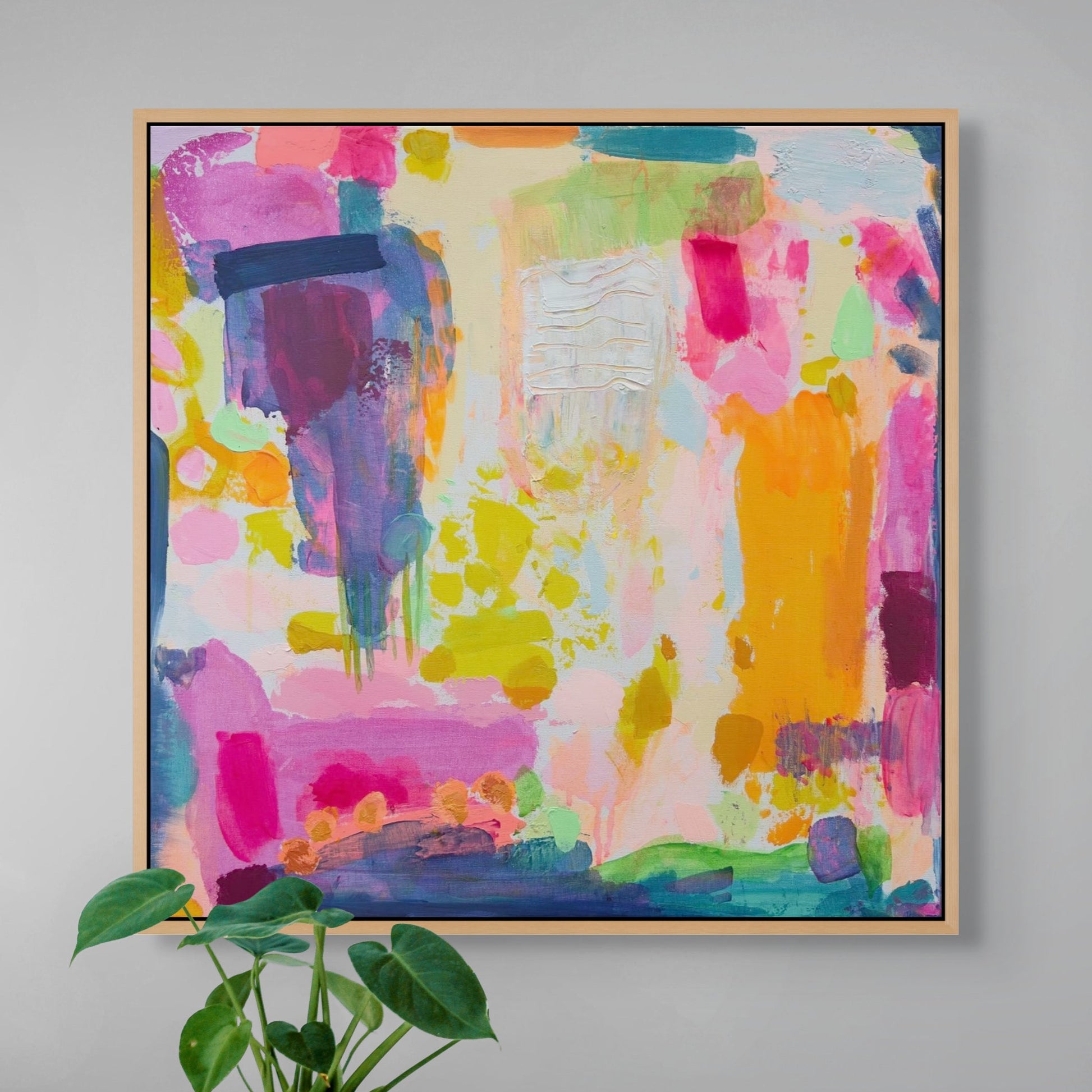 Colourful abstract painting by kathryn sillinceon a gray wall with a plant in the foreground.