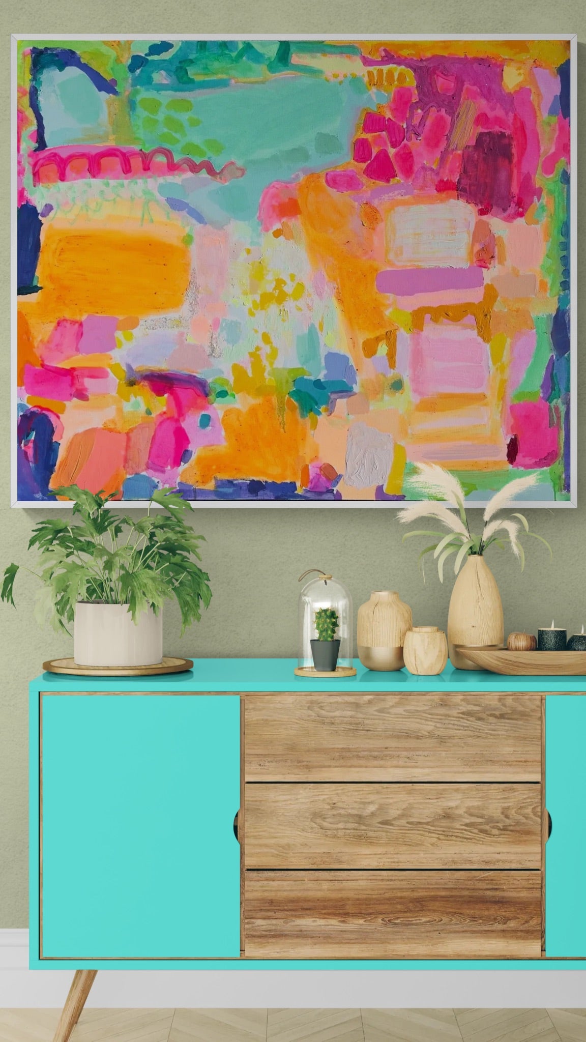 Colorful abstract painting above a turquoise console table with wooden drawers.