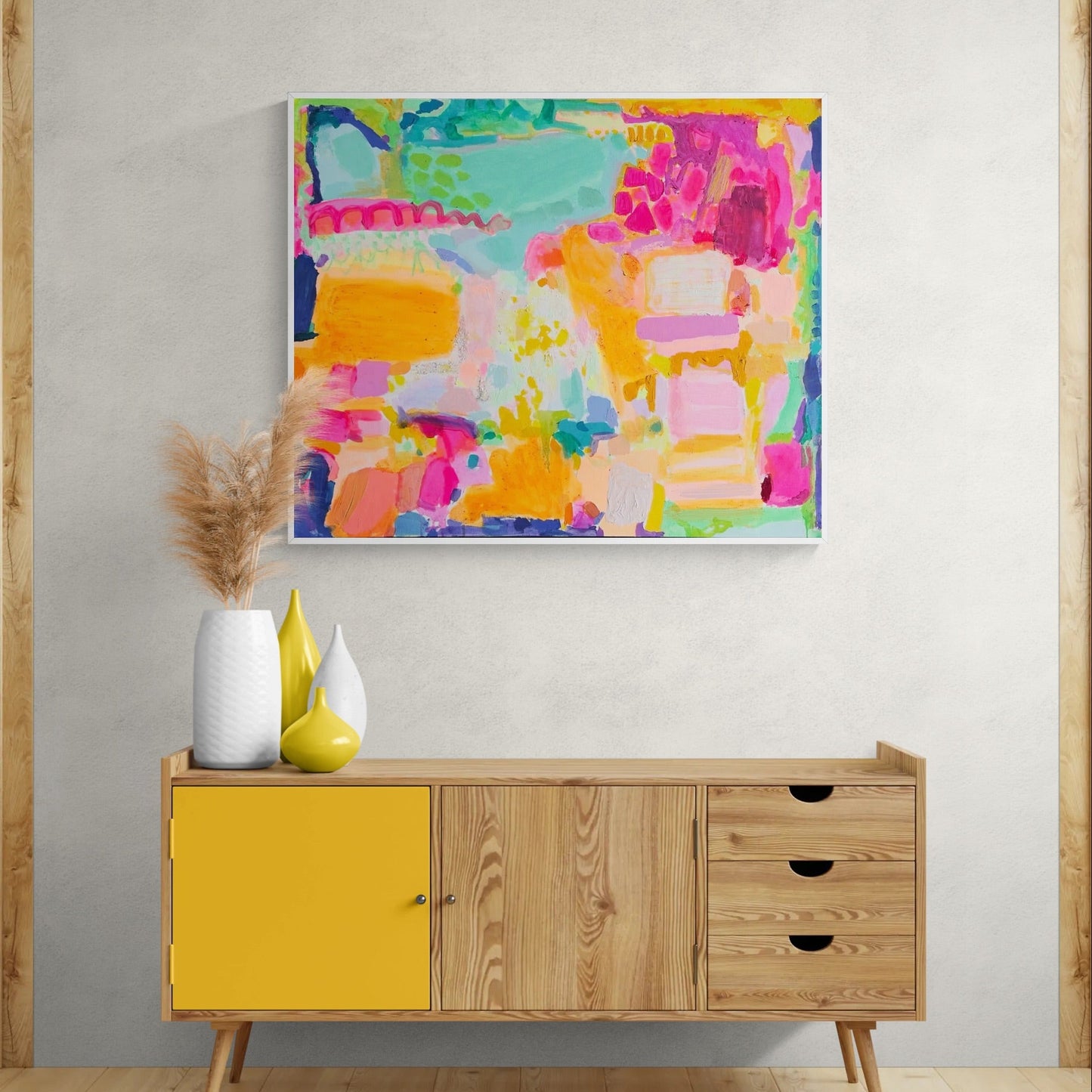 Colorful abstract painting on a wall above a wooden sideboard with yellow doors.