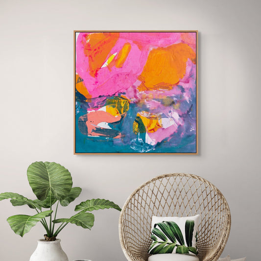 Modern interior with a colorful abstract painting, wicker chair, and plants.