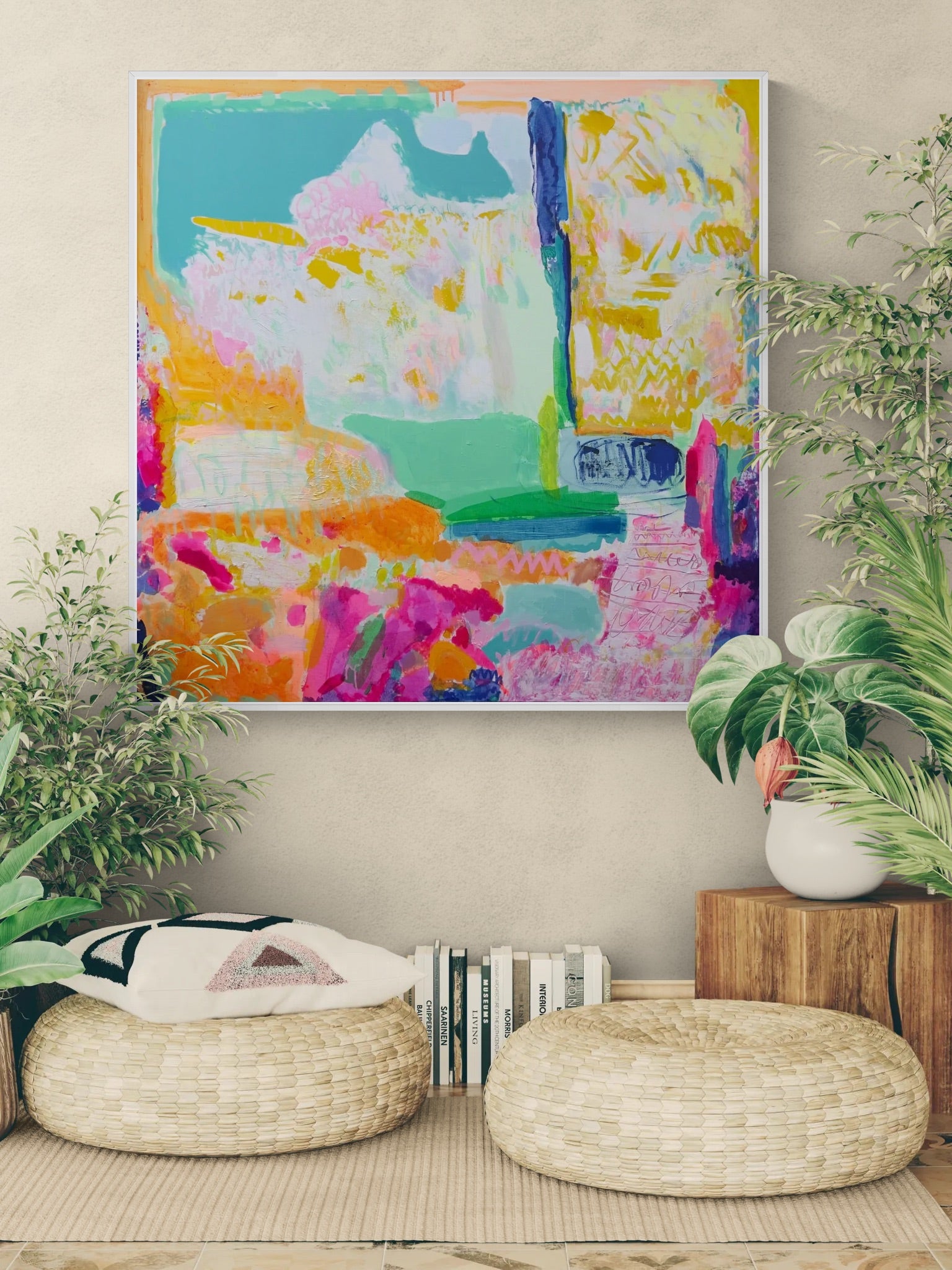 Colorful abstract painting on a wall above two woven stools with plants around.