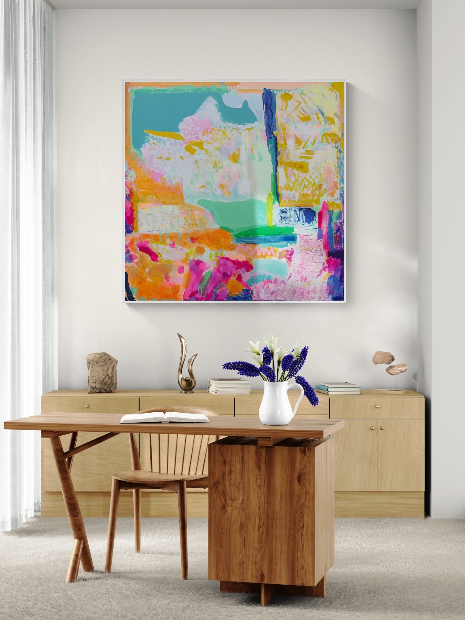 Colorful abstract painting on a wall above a wooden desk with a chair.