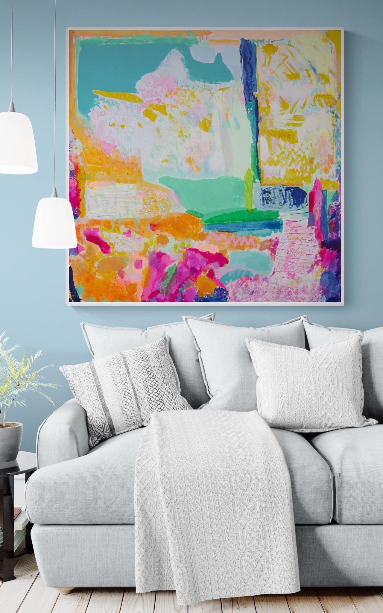 Living room with a gray sofa, white blanket, and colorful abstract painting on the wall.