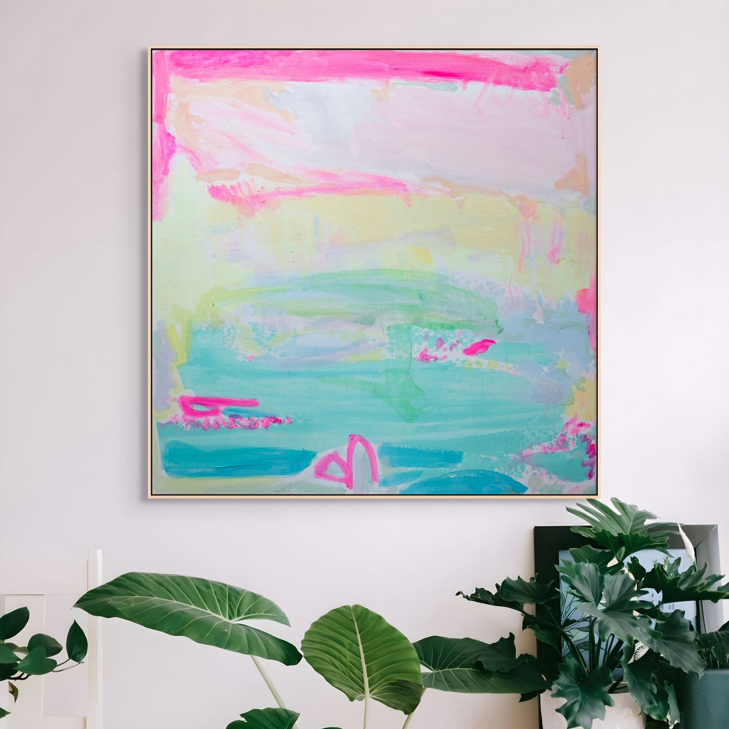 Colorful abstract painting on a wall with plants in the foreground